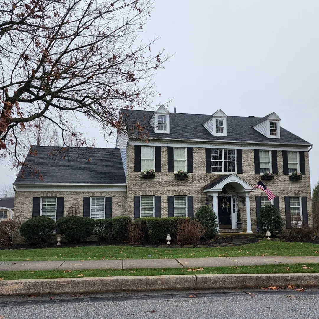 Two-story house with American flag outside.
